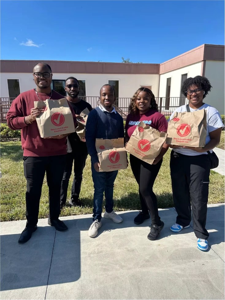 Outlet members serving the community with food bags